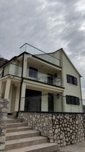 a house with a stone wall and stairs at Casa Oliva in Orahovo
