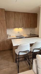 a kitchen with wooden cabinets and a counter with chairs at Casa Oliva in Orahovo