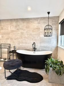 a bathroom with a black tub and a potted plant at luxury Beachfront Home With Private Beach Access in Charlottetown +79 photos