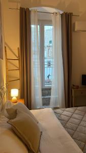a bedroom with a white bed and a window at Casa Buena Vida (locazione ad uso turistico) in Monopoli