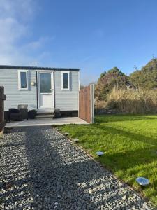 a house with a garden and a gravel driveway at The Pod in Abererch