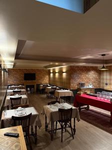 a restaurant with tables and chairs and a red piano at Hotel du Pot d'Etain in Chalons en Champagne