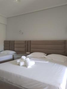 a white bed with two rolled towels on it at Victoria Studio Himara in Himare