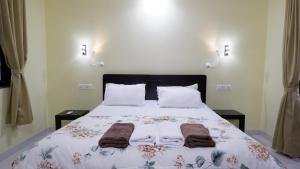 a bedroom with a bed with towels on it at Jasmine Guest House in Majorda
