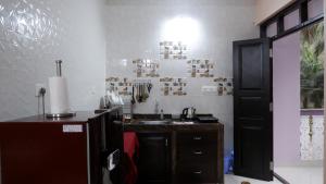 a kitchen with a sink and a counter top at Jasmine Guest House in Majorda +26 photos