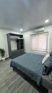 a bedroom with a large bed and a window at Riverside Apartments in Jacó