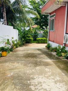 a driveway next to a house with a red building at Roi immo 2 in Mahajanga