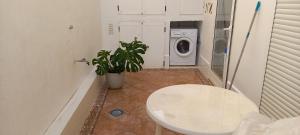 a bathroom with a toilet and a washing machine at Planta baja junto al mar con barbacoa in El Brosquil