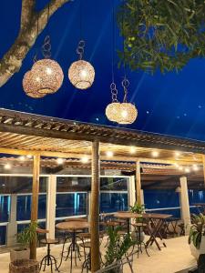 a patio with tables and chairs and chandeliers at Pousada de Itajuípe em Itajuípe in Itajuípe