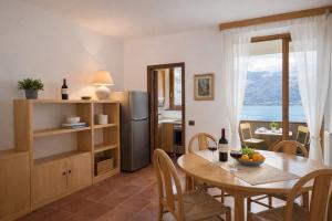 a kitchen and dining room with a table and a view at SunLake Apartment in Colico