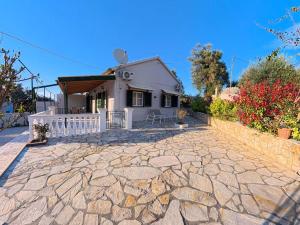 a small white house with a stone driveway at The Homey in Sidari