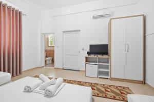 a white room with a bed and a television at Villa Deart Berat in Berat