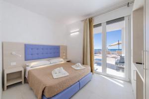 a bedroom with a bed and a balcony with a view at Scirocco Boutique Eco Hotel in Torre Pali