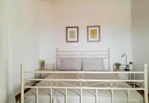 a white bed with two pictures on the wall at ambelos view in Kotronas