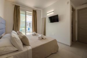 a bedroom with a large bed with a window at Scirocco Boutique Eco Hotel in Torre Pali