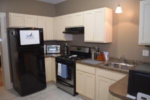 a kitchen with a black refrigerator and a sink at Uptown Geneva Rowhouse Flat in Geneva