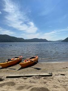 two kayaks sitting on the shore of a lake at Leilighet i Lyngdal in Lyngdal
