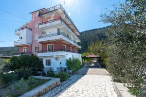 a pink and white building next to a road at Villa Deart Berat in Berat