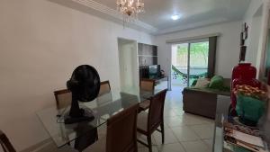 a dining room and living room with a glass table at Ilhéus Temporada in Ilhéus