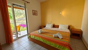 a bedroom with a bed and a balcony at Ionion Hotel in Syvota