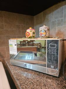 a microwave sitting on top of a counter with vases at Apartaments Malecon 2000 in Guayaquil