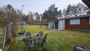 a group of chairs and a table in a yard at Domek Zacisze całoroczny in Świętne