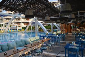 a pool with tables and chairs next to a swimming pool at Beachfront Apprtment on Athens Riviera in Saronida