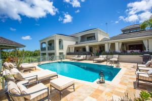 a large house with a swimming pool and chairs at Sweet Dreams in Saint James