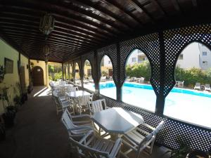 un patio avec des tables et des chaises à côté d'une piscine dans l'établissement Riad Zahra, à Essaouira