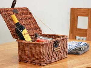 a basket with a bottle of wine on a table at Haven Cottage in Kirkcudbright +26 photos