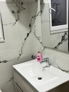 a bathroom with a white sink and a mirror at Villa Cozy in Laknas +4 photos