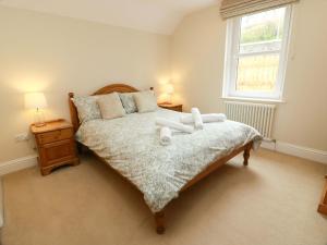 a bedroom with a bed with two pillows and a window at Haven Cottage in Kirkcudbright