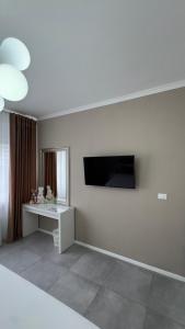 a living room with a table and a television on the wall at B&B Da Jana in Pordenone