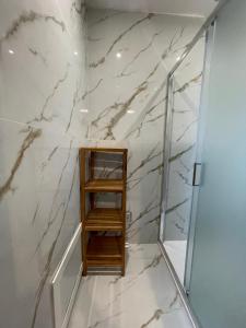 a bathroom with white marble walls and a wooden shelf at Historic family house in Montefiascone +33 photos