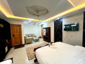 a bedroom with a bed and a living room at The Canvas Hotel in Abbottabad +44 photos