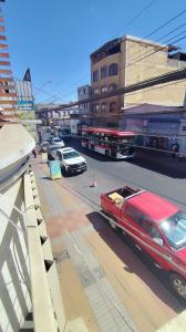 a red limousine driving down a city street with cars at Hostal Verona in Antofagasta