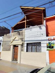 a white building with a roof on a street at Hostal Verona in Antofagasta