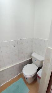a bathroom with a white toilet and a blue rug at Hostal Verona in Antofagasta