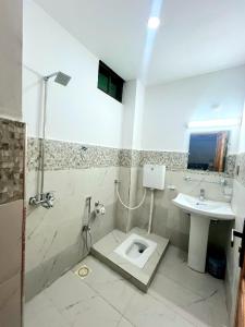 a bathroom with a toilet and a sink at The Canvas Hotel in Abbottabad