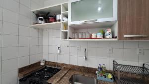 a kitchen with a sink and a counter top at Ilhéus Temporada in Ilhéus