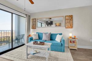 a living room with a blue couch and a table at Seawind Sanctuary in Carolina Beach
