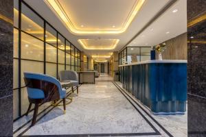an office lobby with a blue counter and chairs at Hotel Anu Plaza - Newly Built Hotel With Parking Just 6 Mins from Connaught Place ,New Delhi Railway Station & Metro Station in New Delhi