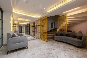 a living room with two couches and a staircase at Hotel Anu Plaza - Newly Built Hotel With Parking Just 6 Mins from Connaught Place ,New Delhi Railway Station & Metro Station in New Delhi