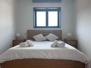 a bed with three towels on it with a window at Bio Home La Asomada in Tías