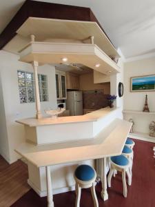a kitchen with a large island with stools at Centro, Rua Coberta, perto de tudo! in Gramado