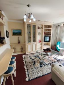 a living room with a glass table and chairs at Centro, Rua Coberta, perto de tudo! in Gramado