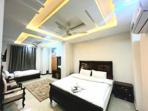 a bedroom with a large bed and a couch at The Canvas Hotel in Abbottabad