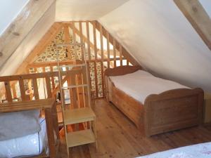 a attic room with a bunk bed and a ladder at Gites laurent in Guissény