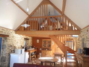 a kitchen with a wooden ceiling with a wooden table at Gites laurent in Guissény