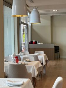 a dining room with tables with white table cloth at Riviera Boutique Hotel by Pomo d'oro in Vlorë